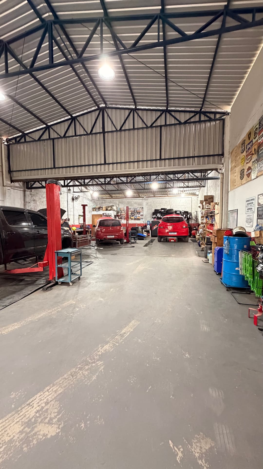 Interior da oficina DW Auto Center com três elevadores